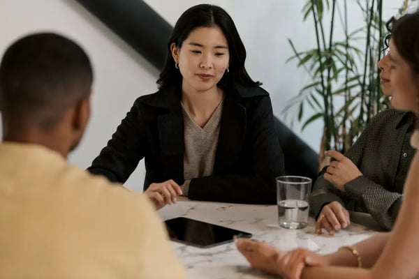 Person am Tablet diskutiert mit anderen Personen über die Umsätze