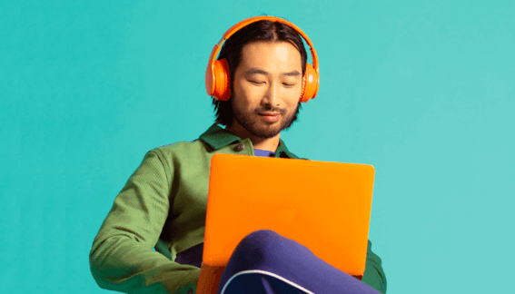 Mann, der an einem Laptop arbeitet und lächelt